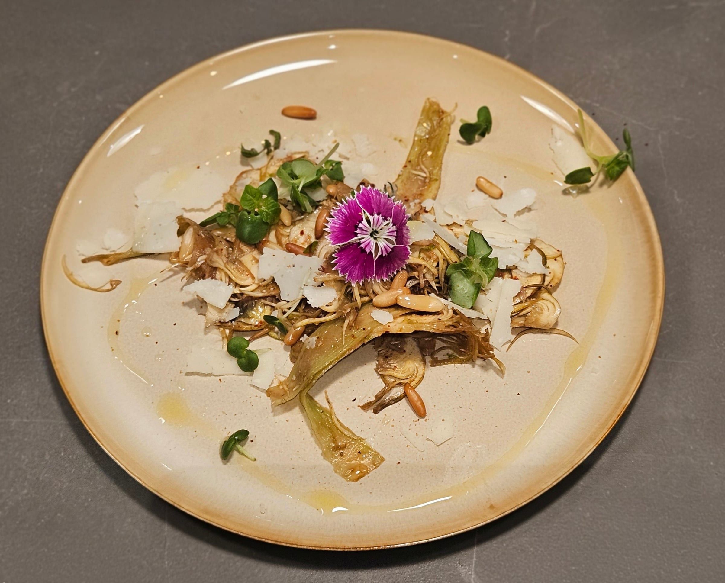 A seared fish fillet plated with vegetables and herbs.