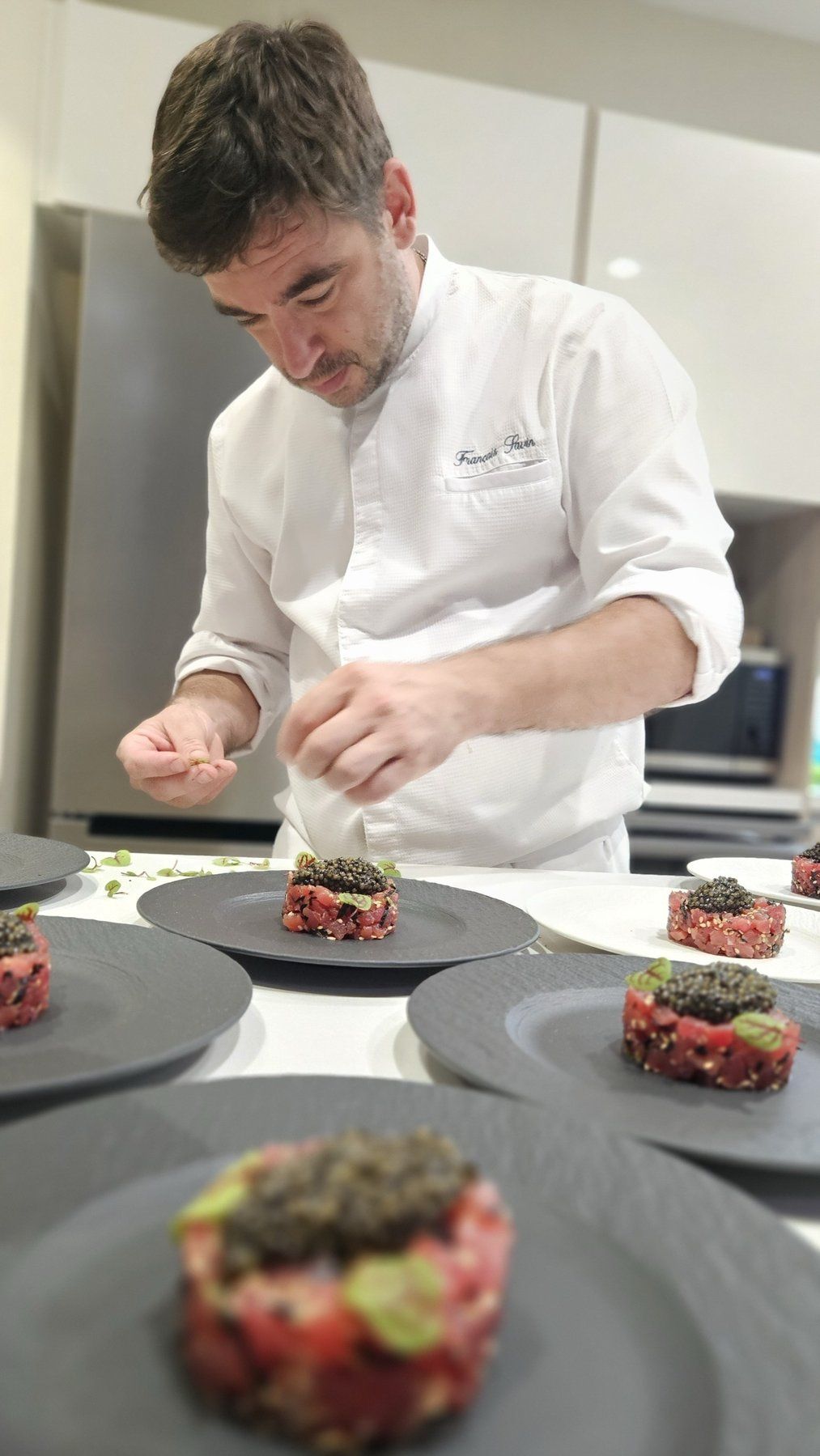 Chef François Savin plating a series of tartares during service.