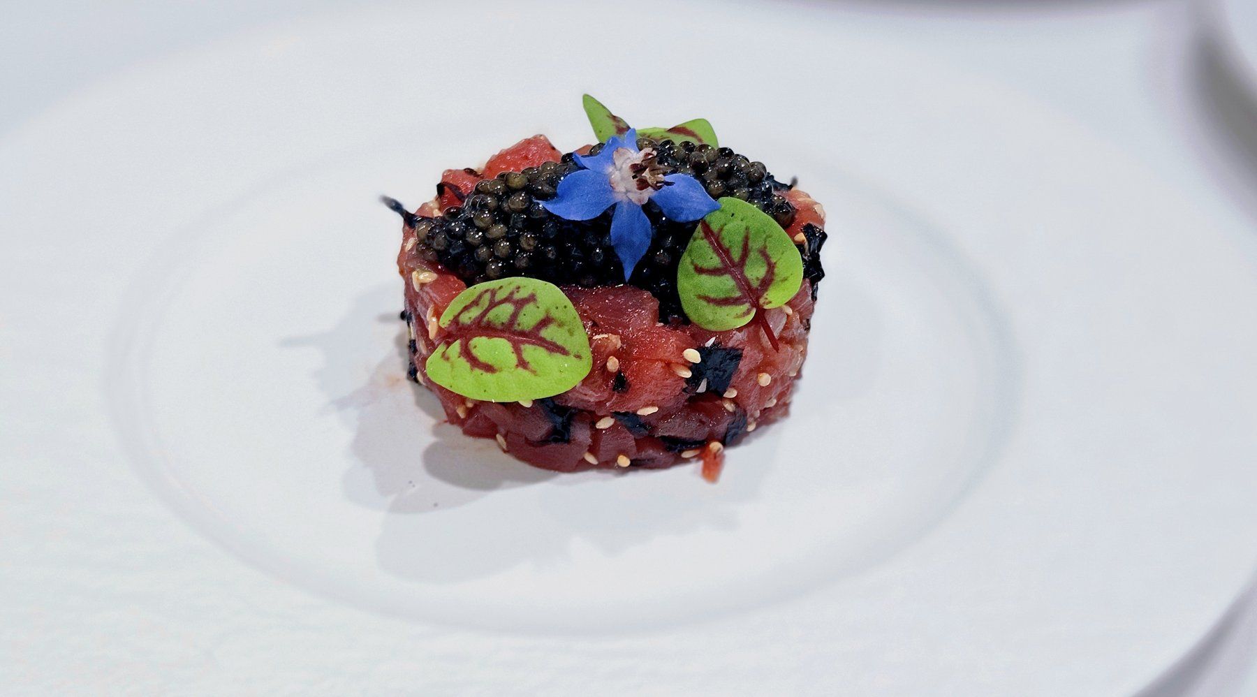 Tuna tartare topped with caviar, sorrel leaves and a borage flower.